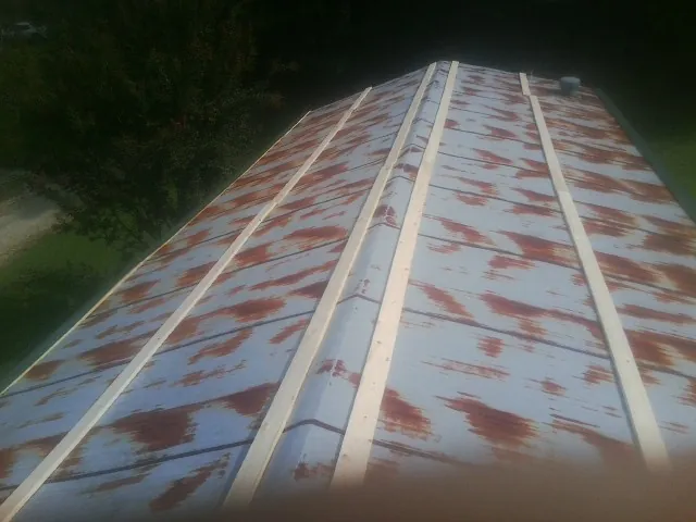 Rusted metal roof panels with new wood purlins before replacement — Storm Damage Roof Repair in North Falmouth by Roofing Brothers