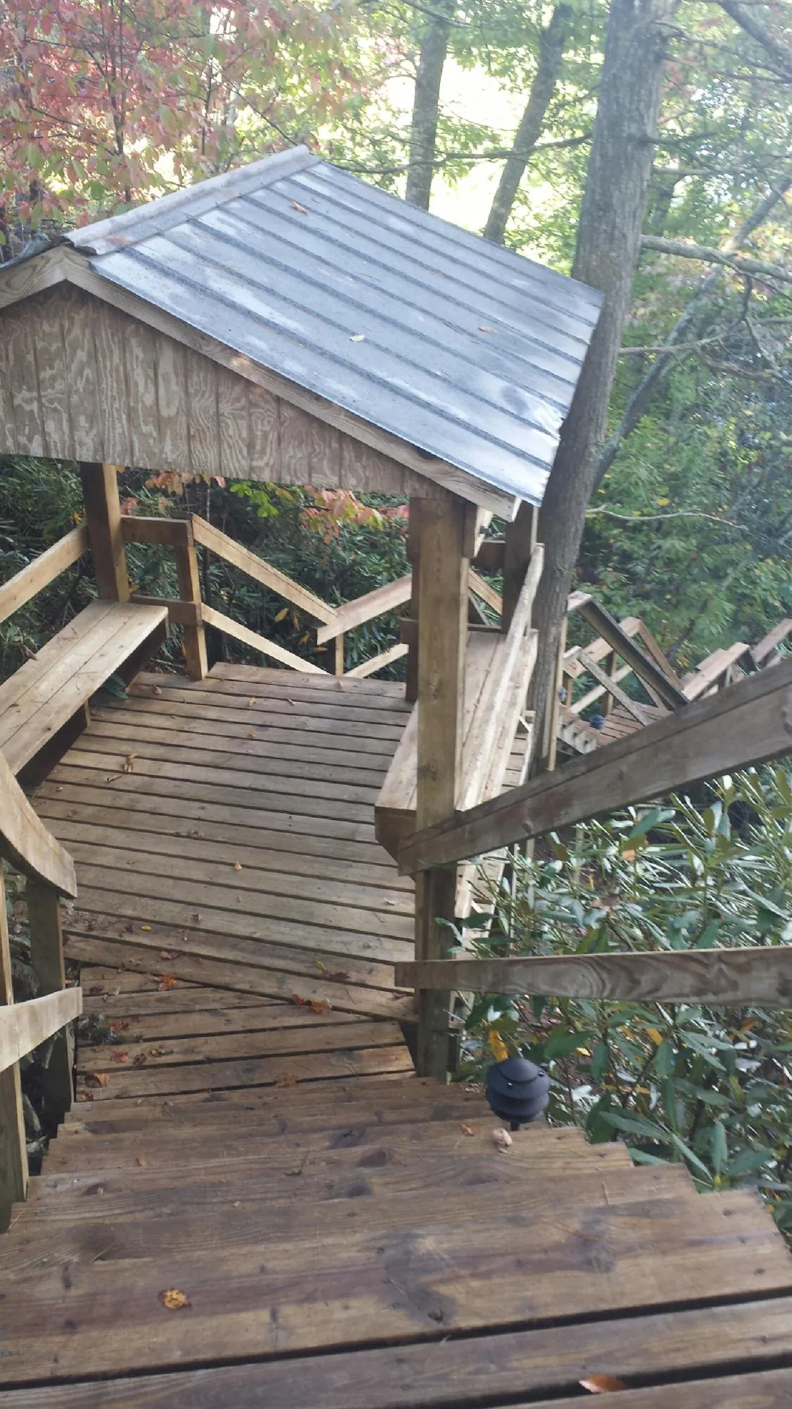 Metal roofed shelter over wooden steps on a wooded walkway — Skylight Repair & Installation work by our crew in North Falmouth
