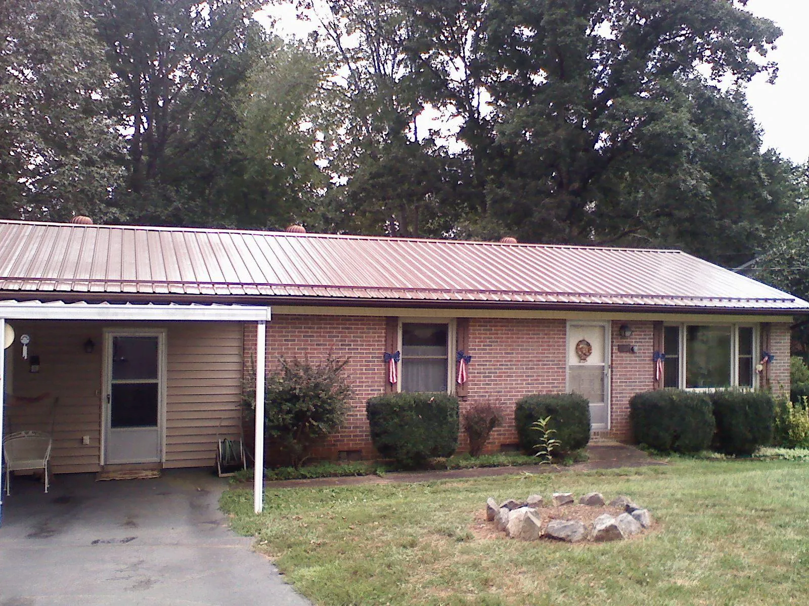 Bronze metal roof and carport on a brick ranch home — Roof Repair work by our crew in North Falmouth